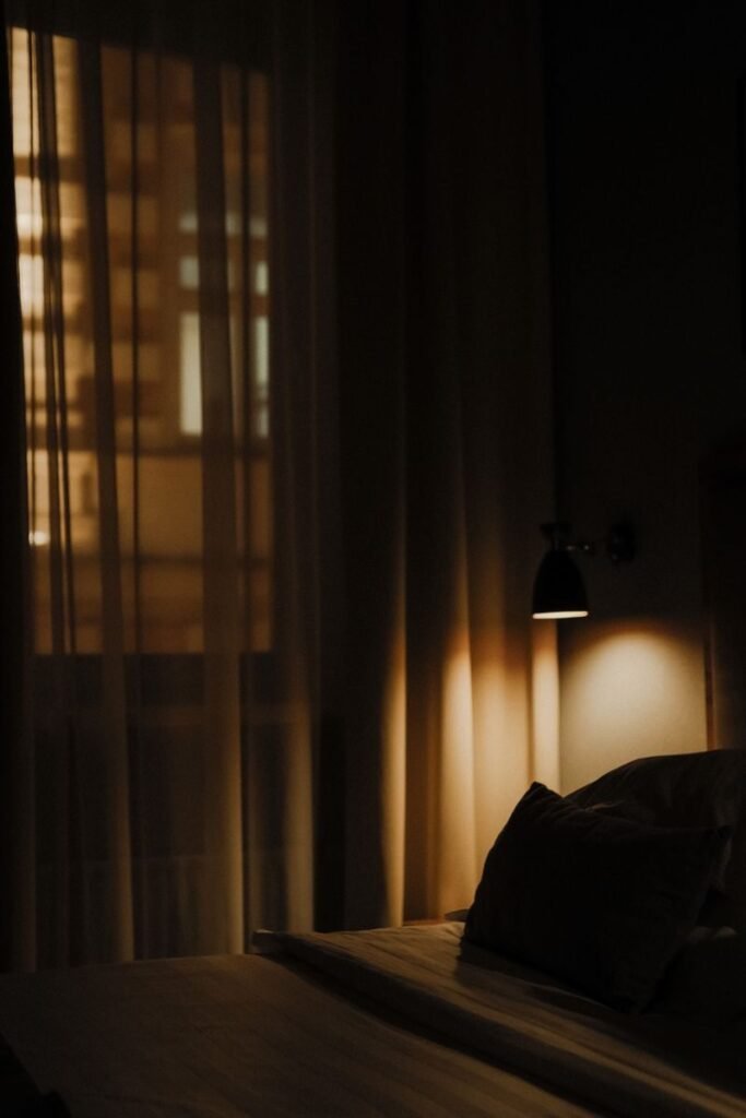 Dark bedroom with heavy curtains drawn across a window