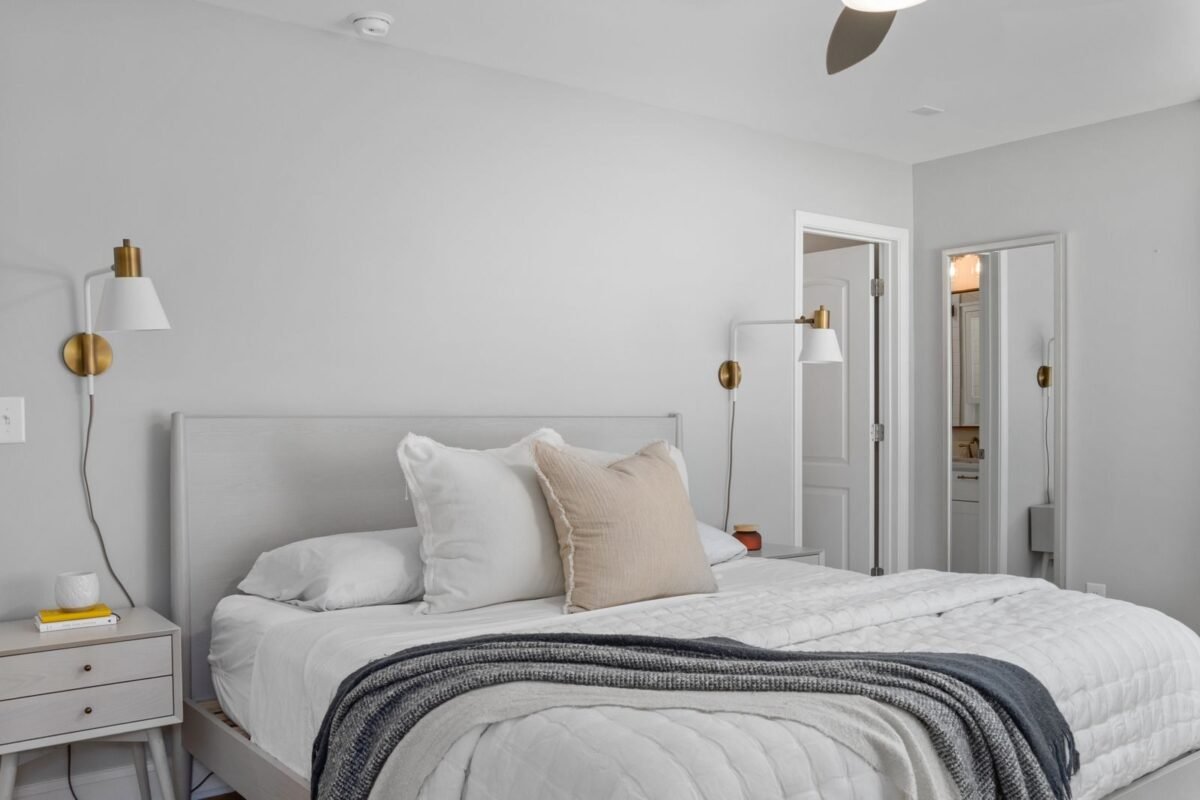 Calm neutral bedroom with soft natural light and simple bedding