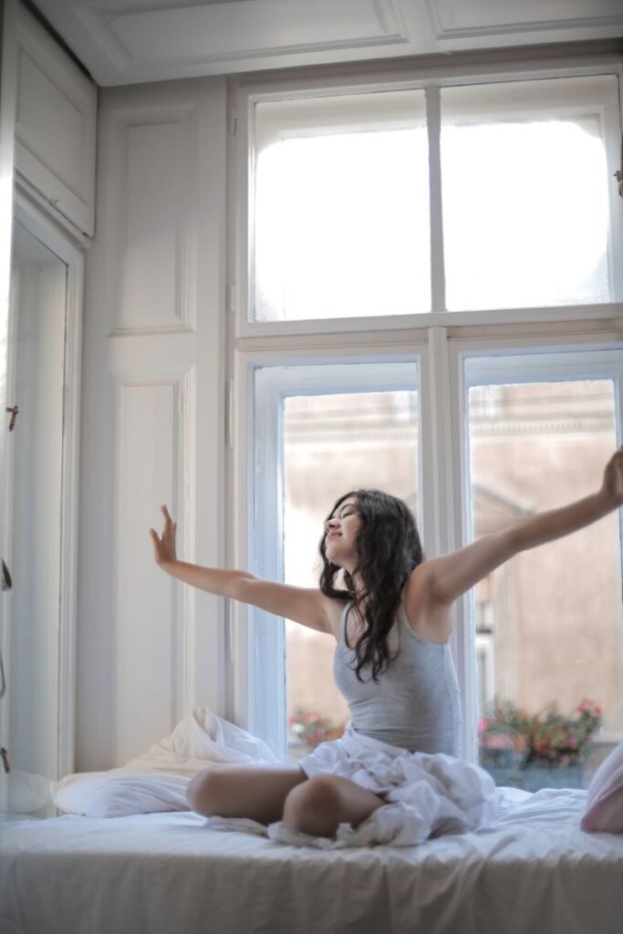 Morning light coming through a bedroom window onto white bedding